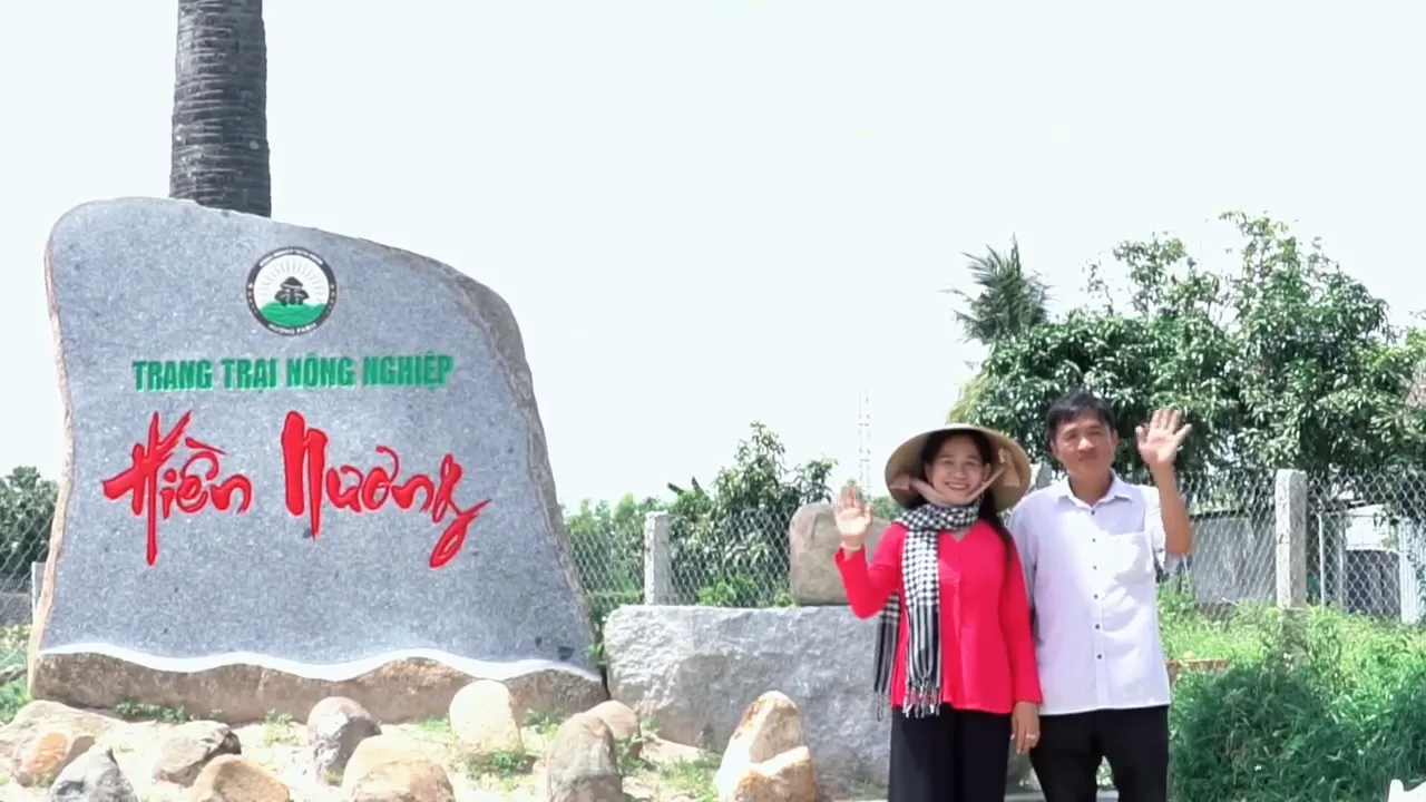 Chị Châu Thị Nương và anh Trần Phương Hiền vẫy tay bên tảng đá khắc tên Trang trại Nông nghiệp Hiền Nương
