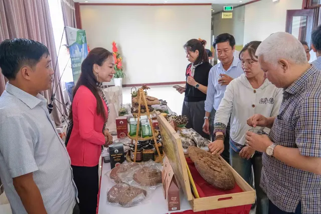 Chị Nương giới thiệu các sản phẩm nấm dược liệu với khách bên một bàn trưng bày