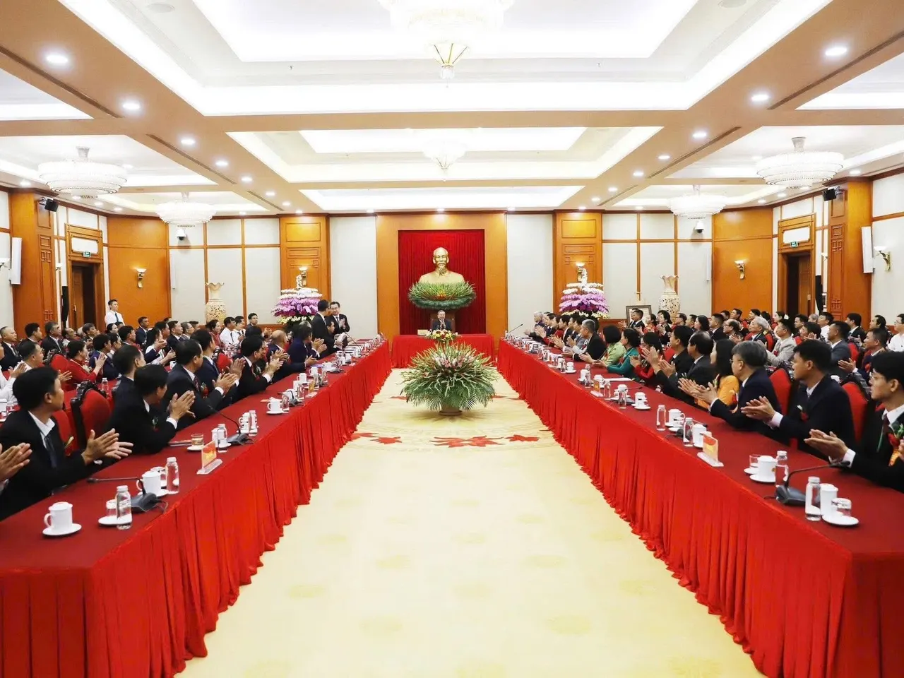 Toàn cảnh hội trường với hai dãy bàn phủ khăn đỏ, đại biểu ngồi kín hai bên