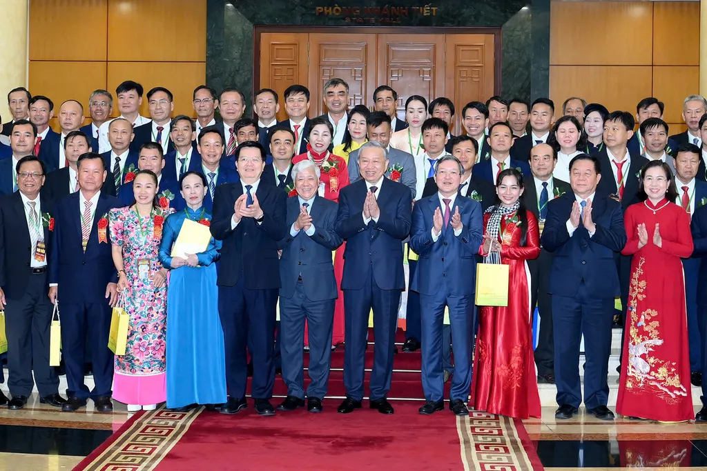 Ảnh chụp chung các đại biểu nông dân tại Phòng Khánh Tiết; chị Châu Thị Nương mặc áo dài đỏ, quàng khăn rằn, đứng ở phía bên phải